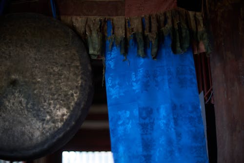 Sacred silk scarf and gong hanging in ancient oriental building