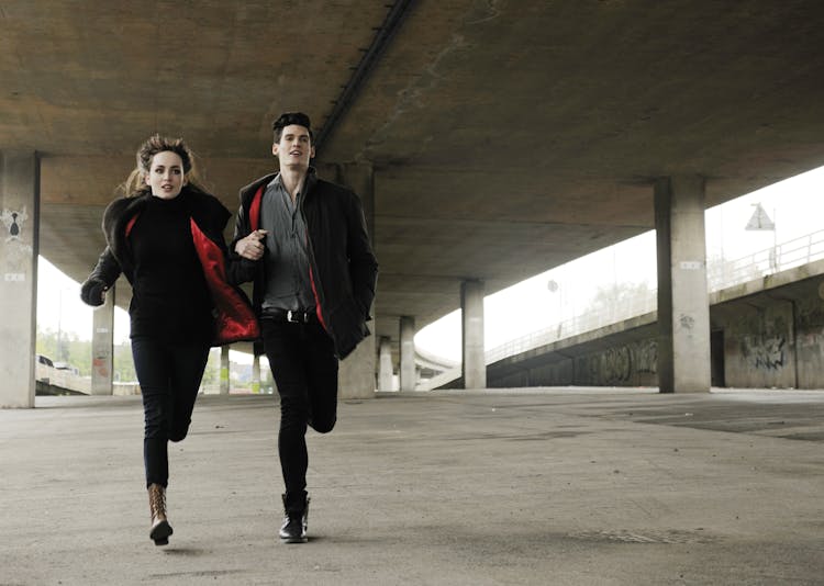 Man And Woman Running Under Bridge