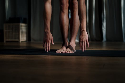 Adult man stretching during yoga session on mat indoors, promoting wellness and flexibility.
