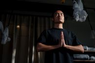一名成年男性在瑜伽馆练习冥想，专注于正念与幸福