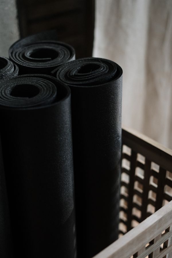 Rolled exercise mats stacked in a woven basket — photo by cottonbro studio on Pexels