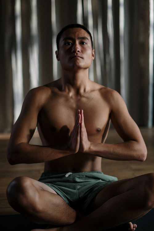 Free Shirtless man practicing yoga in a serene indoor studio, promoting health and mindfulness. Stock Photo