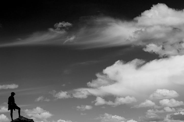 Hiker On Mountaintop Against Sky