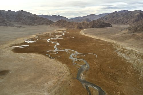Free Drone view of narrow riverbeds flowing on rough terrain near mountains in daytime Stock Photo