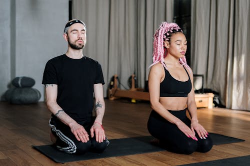 Woman in Black Tank Top Sitting Beside Man in Black Tank Top