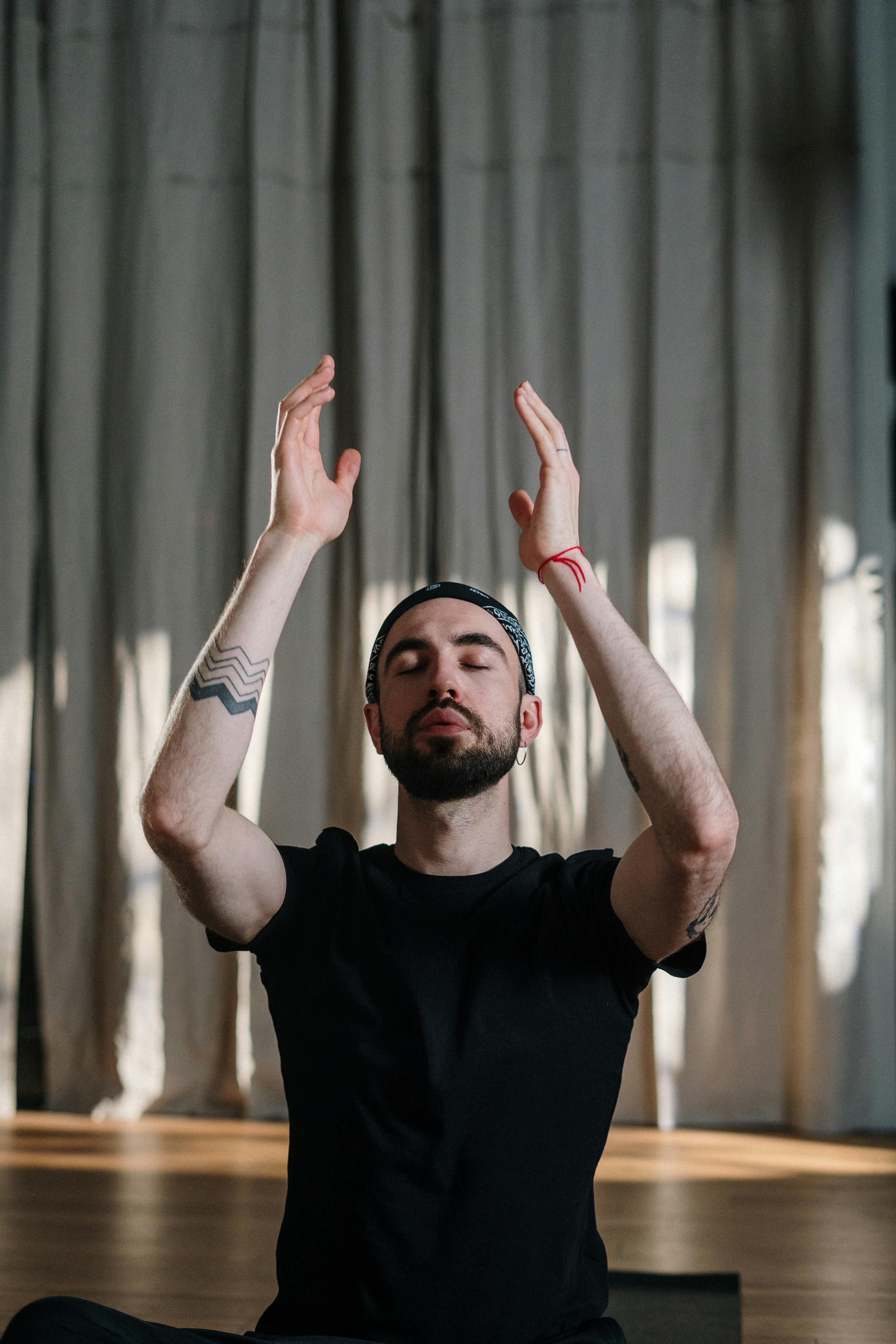 A man practicing meditation in a serene yoga studio setting, focusing on mindfulness and wellbeing.