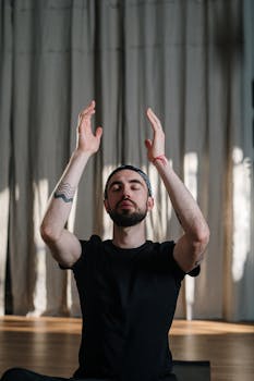 A man practicing meditation in a serene yoga studio setting, focusing on mindfulness and wellbeing.