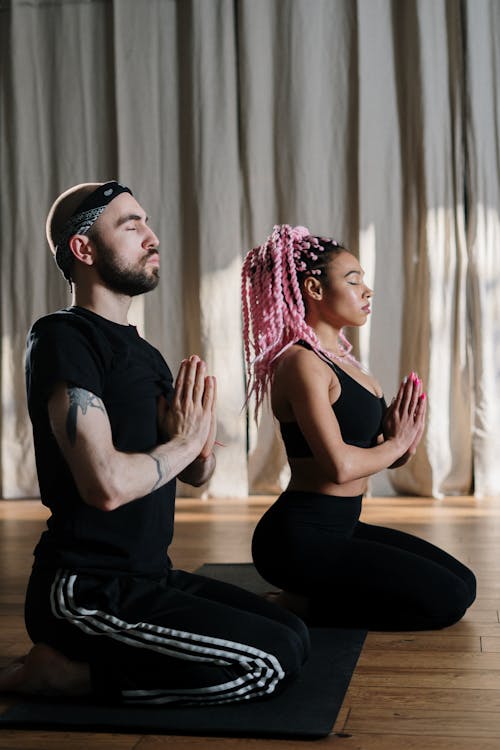 Man in Black Tank Top and Woman in Black Tank Top Sitting on Floor