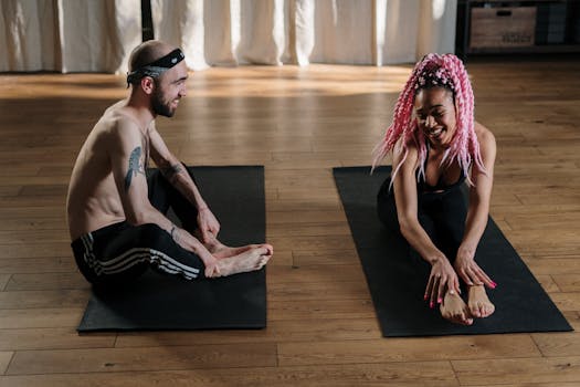 A man and woman together practicing yoga indoors, emphasizing health and wellness.
