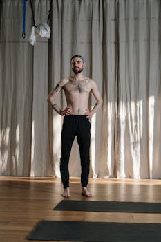 Shirtless man in yoga studio, ready for practice, embodying health and fitness.