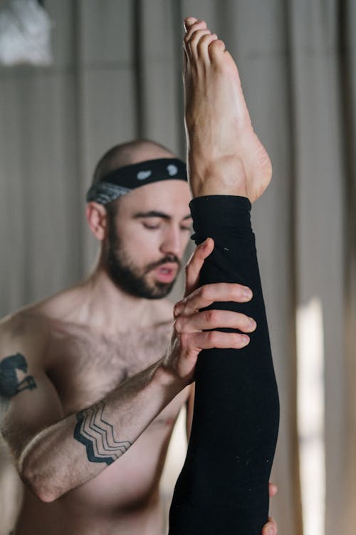 Topless Man in Black Shorts Holding Black Textile