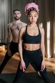 Two individuals practicing yoga in a studio emphasizing health and wellness.