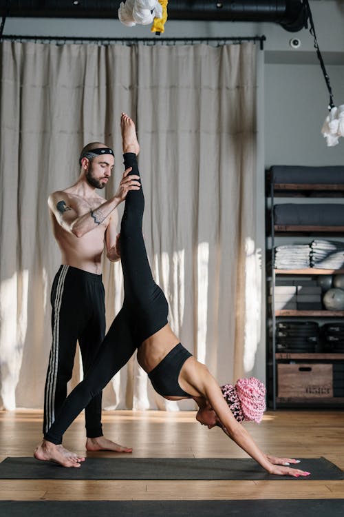 Woman in Black Sports Bra and Black Leggings Doing Yoga Pose