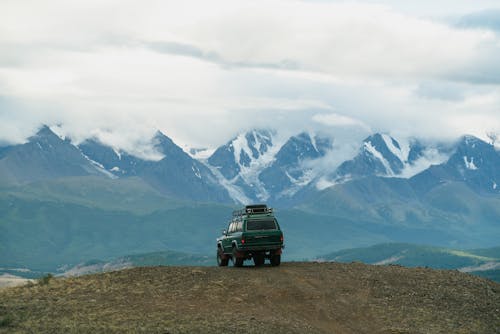 Offroader on rocky terrain near majestic mountains