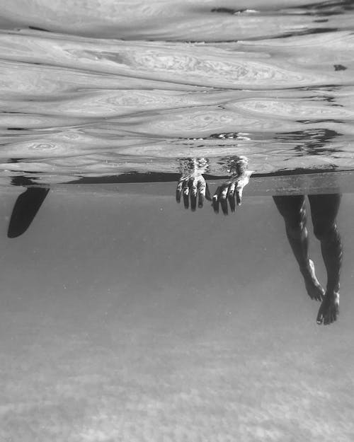 Grayscale Photo of a Person Swimming