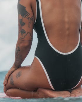 A person with tattoos in a swimsuit enjoying a beach in Hawaii.