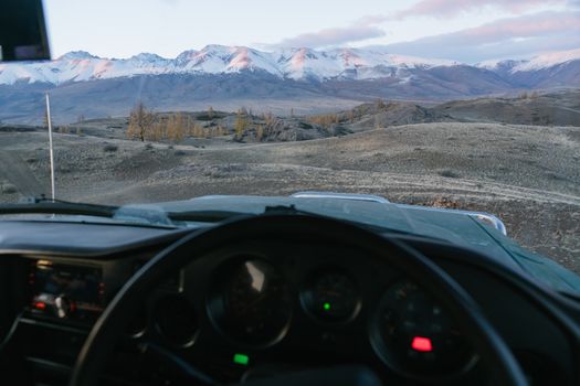Mountains against blue sky seen from inside of car