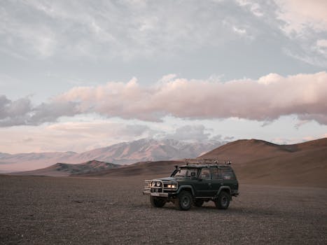 A solitary SUV parked in a serene, picturesque mountain setting during twilight.