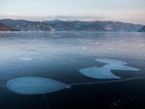 Icy lake surrounded by mountains in winter