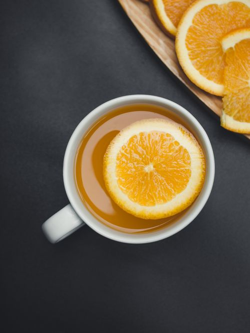 Free Close-up of citrus tea in a ceramic mug with fresh orange slices, ideal for refreshment. Stock Photo