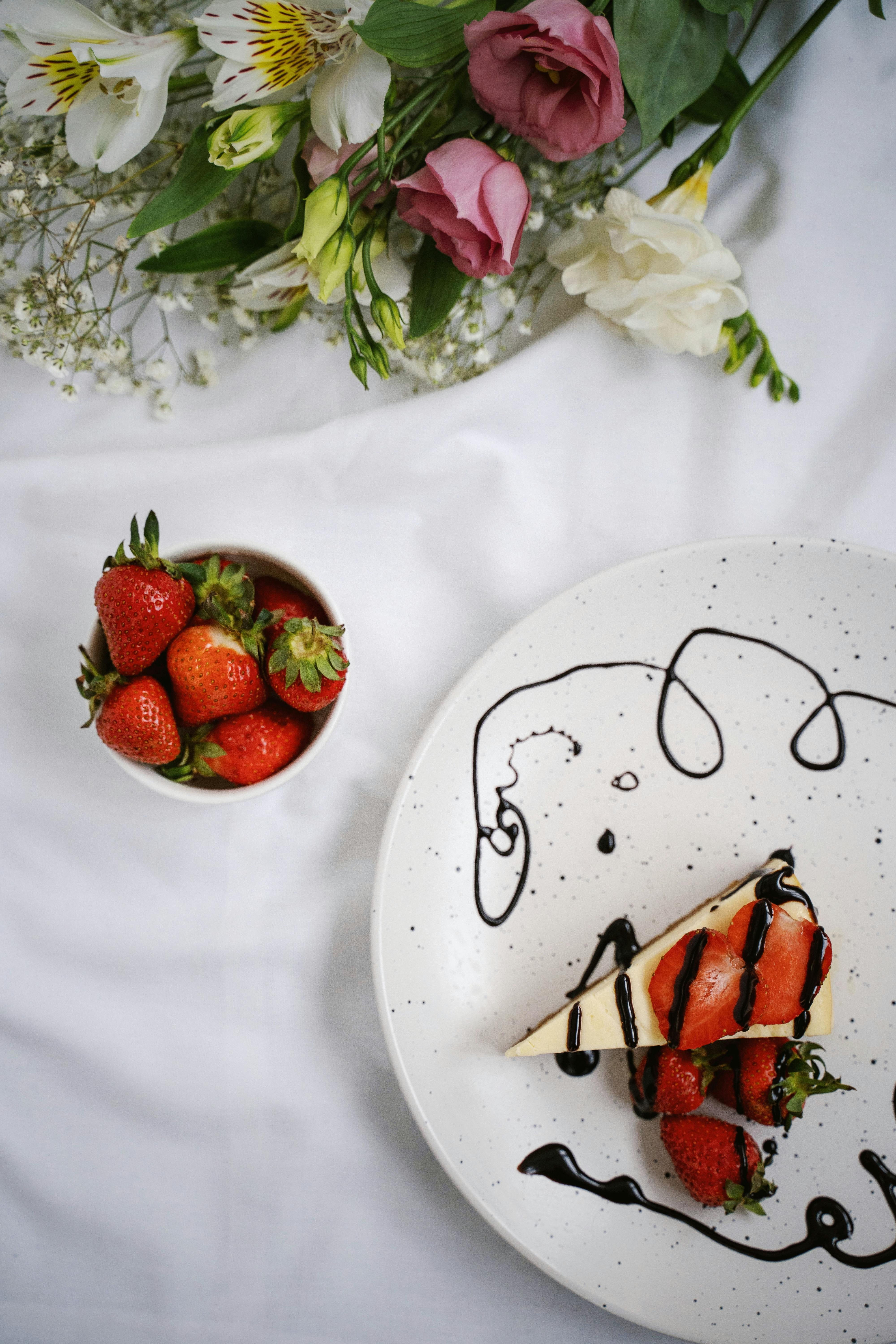 Delicious cheesecake with fresh strawberries and chocolate drizzle on a decorative plate.