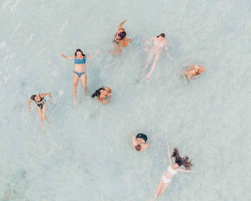 Aerial shot of women enjoying a swim in clear ocean waters, Hawaii.