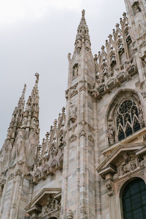 Carved spires of medieval cathedral against cloudy sky