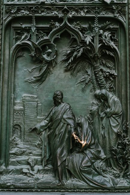 Details of beautiful bas reliefs with biblical scenes on main bronze door of Milan Cathedral