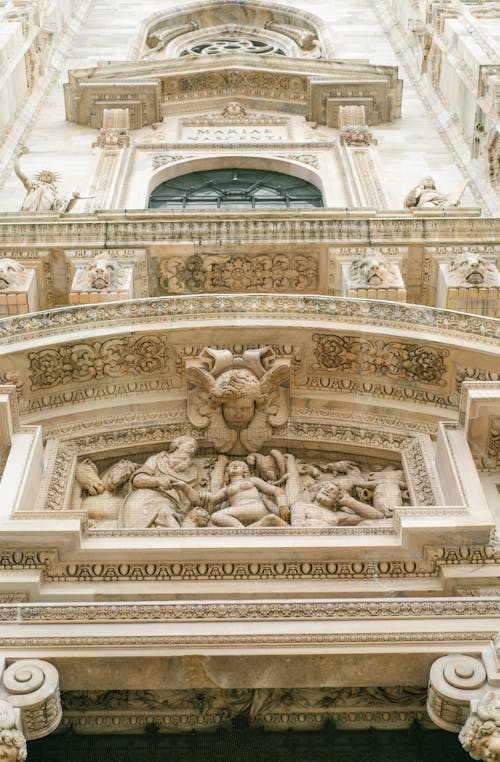 Ornamental details with arches and bas reliefs above entrance of medieval cathedral