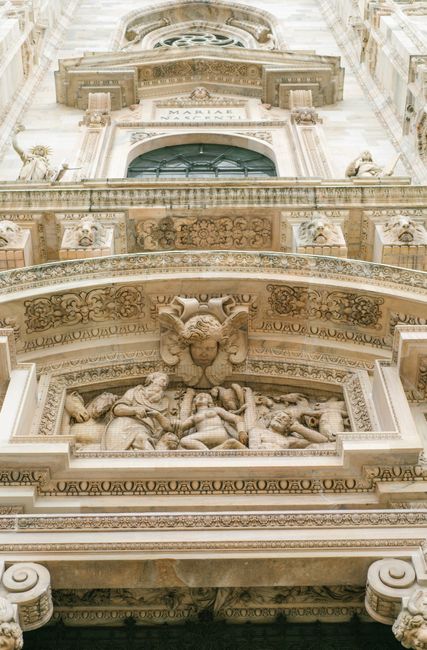 From below of magnificent carved sculptures and bas reliefs on marble facade of ancient cathedral