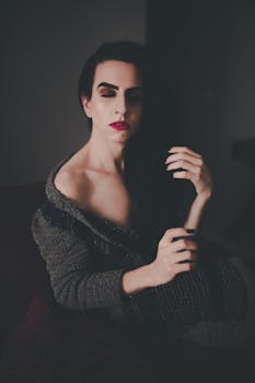 Dramatic portrait featuring a person with red lips and elegant pose, eyes closed.