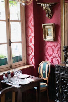 Cozy restaurant corner with vintage decor, red wallpaper, and classic furnishings.