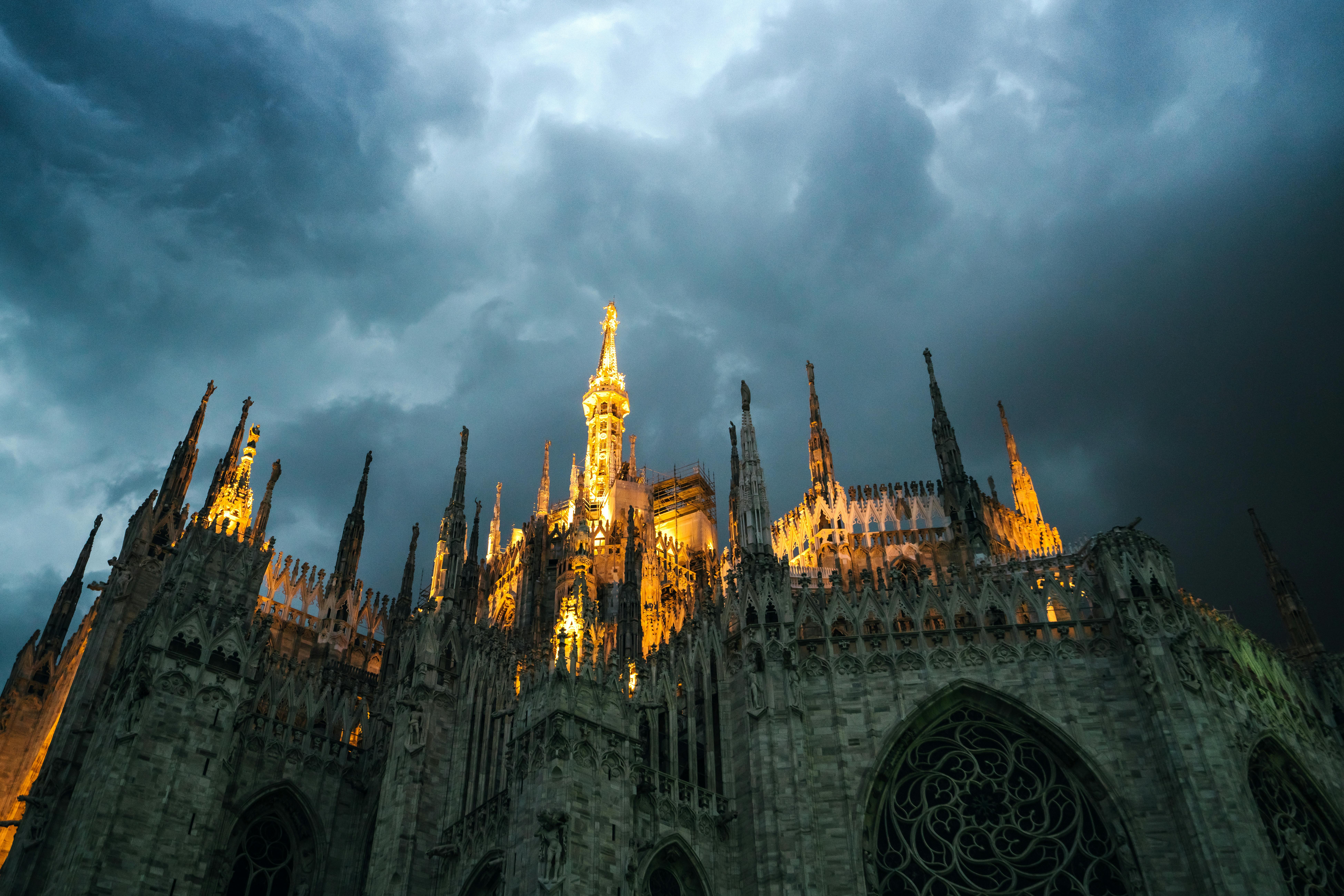 milan cathedral with glowing sharp spires under overcast sky