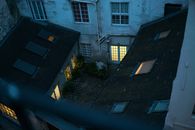 Small backyard with lit windows in twilight viewed from balcony