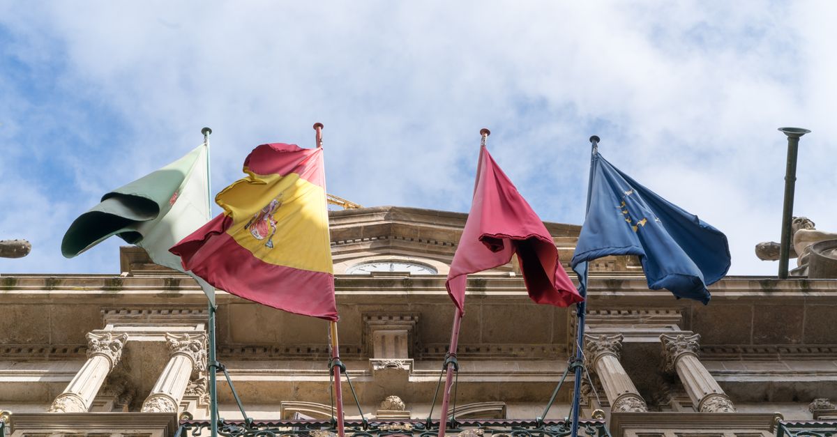 Banderas de España, Italia y la UE en la fachada de un edificio histórico, simbolizando la unidad internacional.
