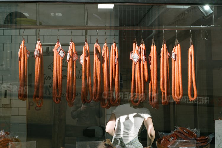 Anonymous Worker With Long Sausages At Meat Processing Plant