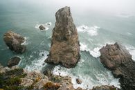 Foamy waves of sea and rocky cliff