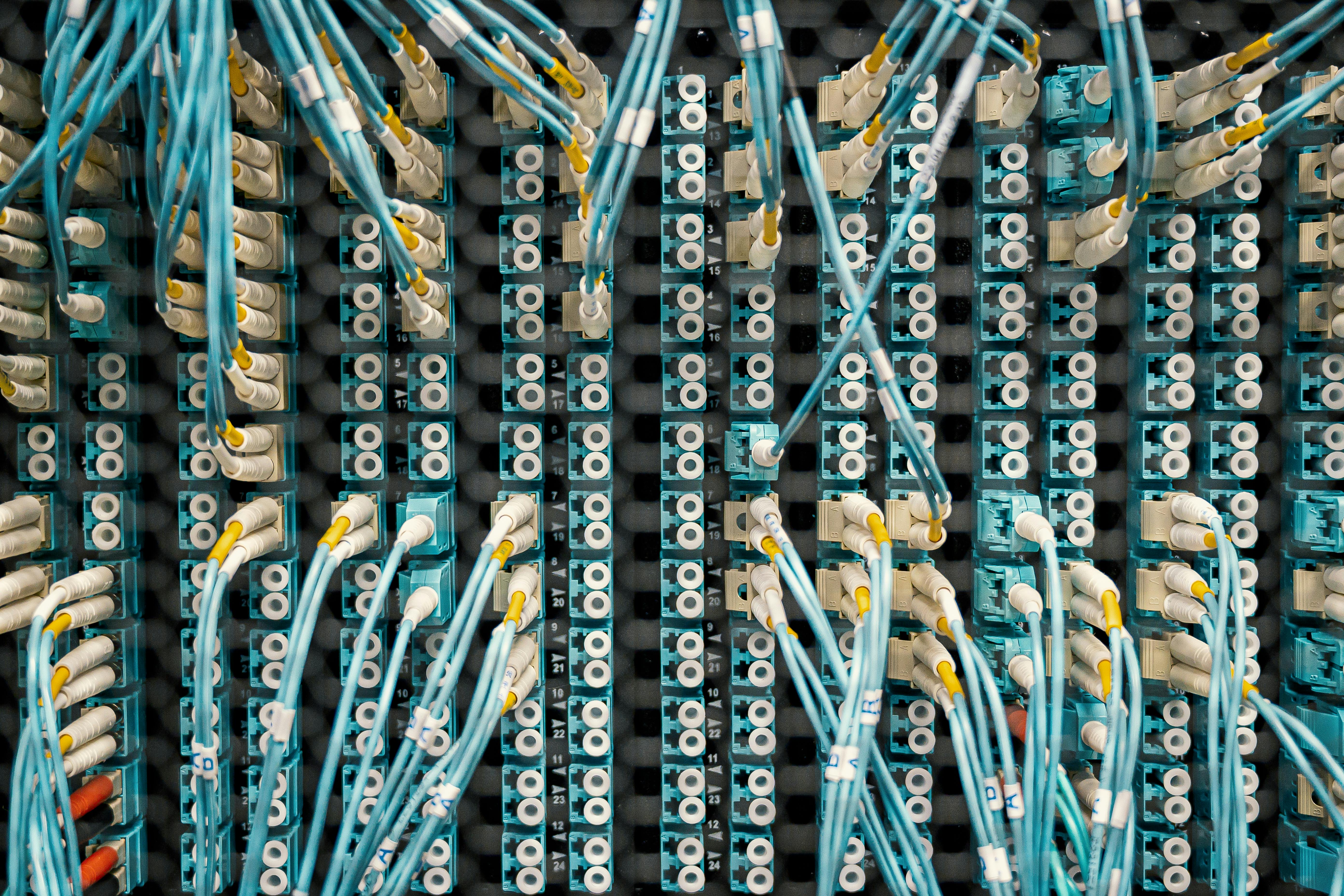 Fibre-optic cables connected to a network patch panel in a data centre communications system