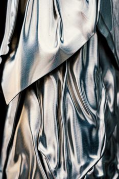 Abstract background of soft metallic fabric with smooth shiny texture hanging as drapery