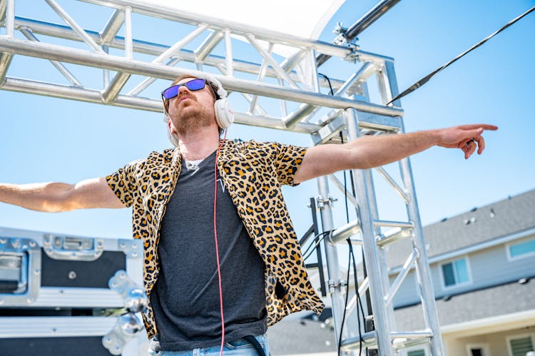 Trendy Young Man In Headphones Dancing On Stage During Music Festival