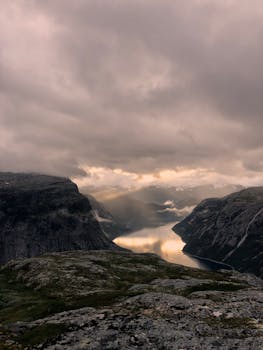 A breathtaking view of Norwegian mountains and a lake under a cloudy sky, captured at Tyssedal.