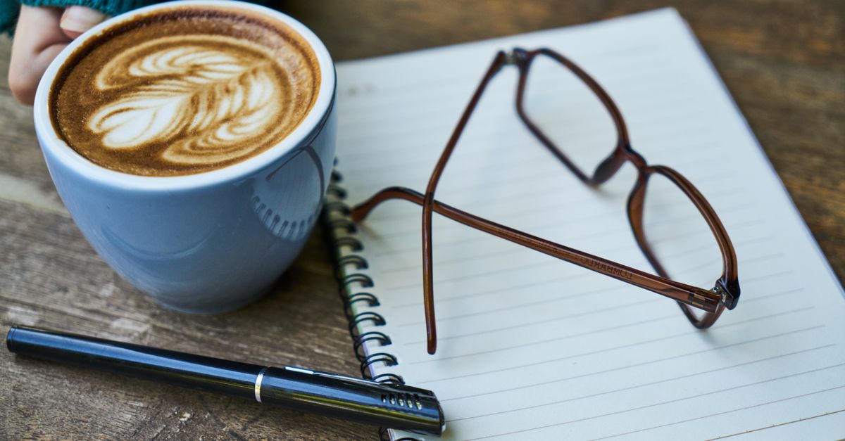 handwritten journal and a cup of coffee on a wooden table