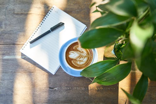 Coffee Latte Beside White Notebook