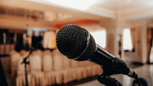 Free Closeup of black modern microphone on stand placed in spacious meeting room with chairs Stock Photo