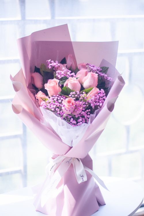 Free Beautiful bouquet with pink roses and Gypsophila wrapped in pink paper. Stock Photo