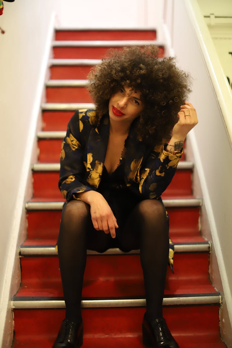 Stylish Woman Sitting On Red Steps