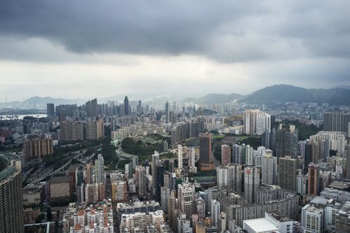 Free Dramatic aerial view of Kowloon's dense skyline under a cloudy sky in Hong Kong. Stock Photo