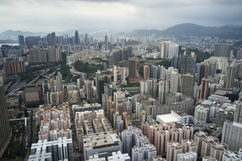 Free Captivating aerial view of Kowloon, Hong Kong with dense skyscrapers and mountains in the background. Stock Photo