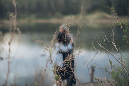 Embracing couple standing on lake shore