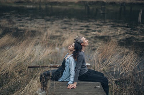 Relaxed couple resting on wooden path